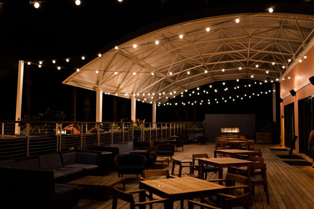 a patio with tables and chairs under a canopy